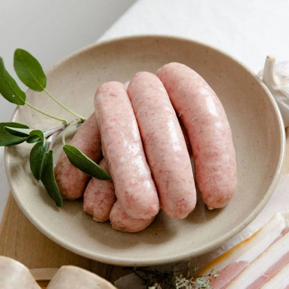 Primrose Herd gluten-free pork sausages arranged on a plate, showing their golden-brown, cooked appearance.