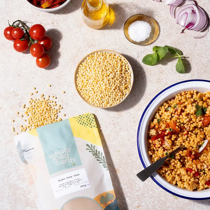 Whole Food Earth giant couscous in a bowl with fresh vegetables, showcasing its large, fluffy texture as a versatile rice and couscous alternative.