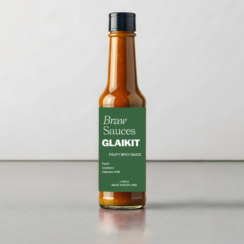 Glaikit sauce by Braw Sauces shown in the image, featuring a glossy, dark sauce in a jar with a label and a spoon ready for tasting.