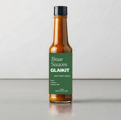 Glaikit sauce by Braw Sauces shown in the image, featuring a glossy, dark sauce in a jar with a label and a spoon ready for tasting.
