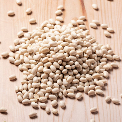 Whole Food Earth haricot beans, dried beans and pulses, showing a close-up of light tan, small, oval-shaped beans in a bowl.