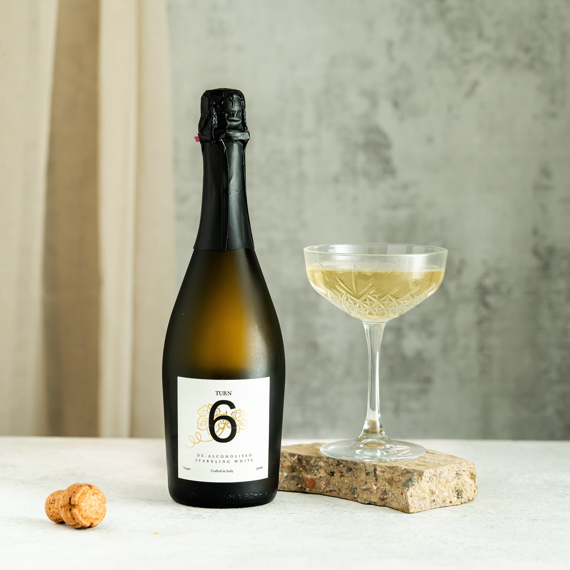 Clear glass flute filled with Turn 6 premium alcohol-free sparkling white wine, showcasing its bubbly, golden appearance.