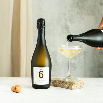 Six bottles of Turn 6 premium alcohol-free sparkling white wine in clear glass bottles with white labels and metal caps.