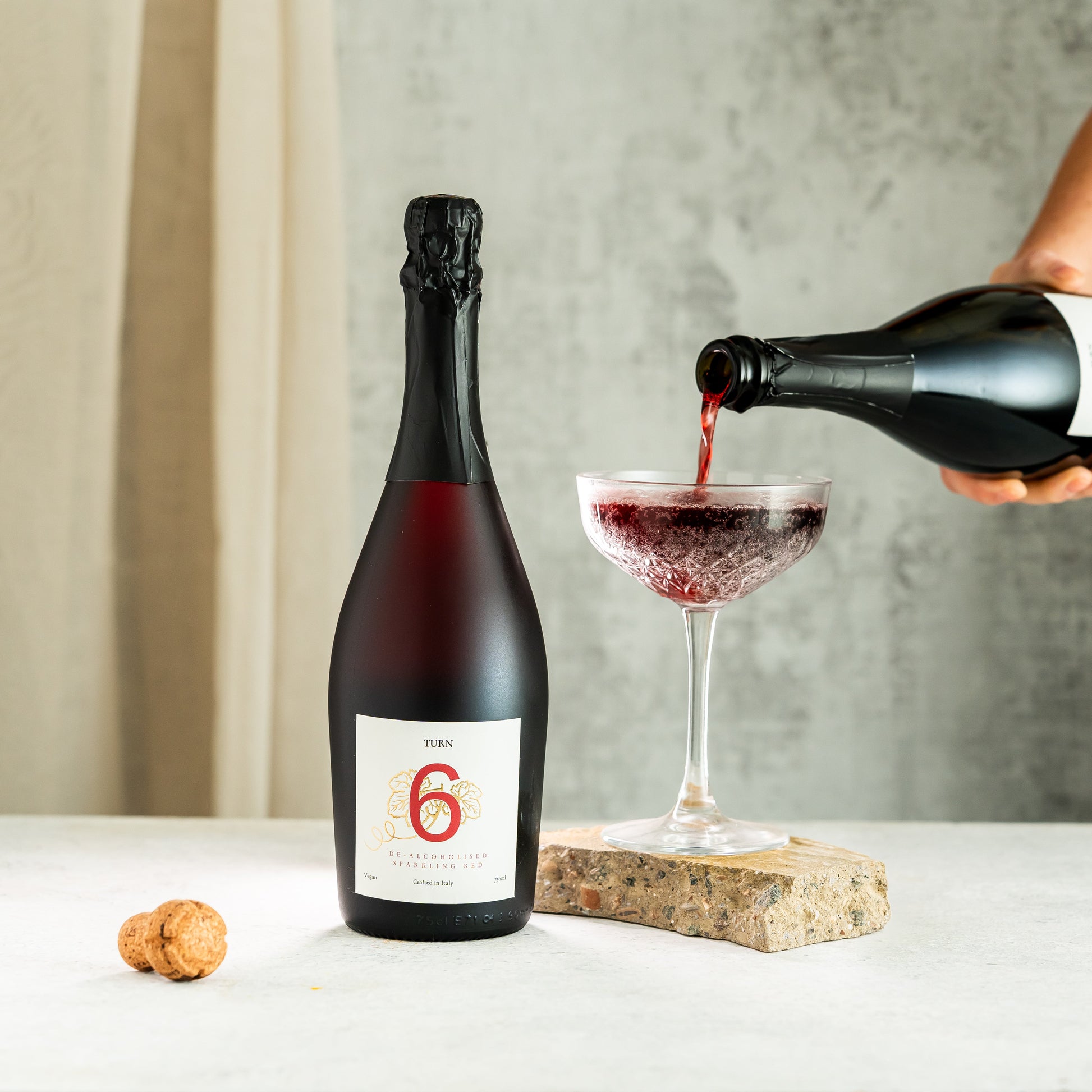 Six bottles of Turn 6 premium alcohol-free sparkling white and red wines in a case, showcasing colorful bottles on a white background.