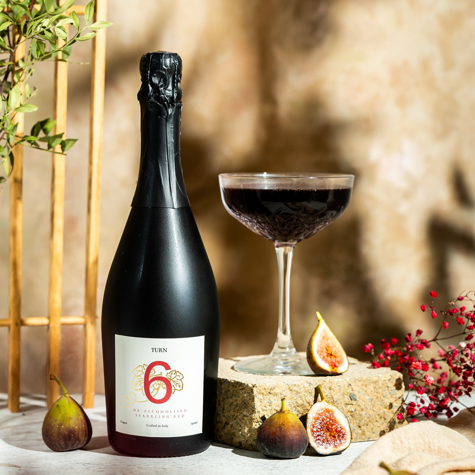 Six bottles of Turn 6 premium alcohol-free sparkling red wine in a case, showcasing vibrant red color and elegant wine bottles.