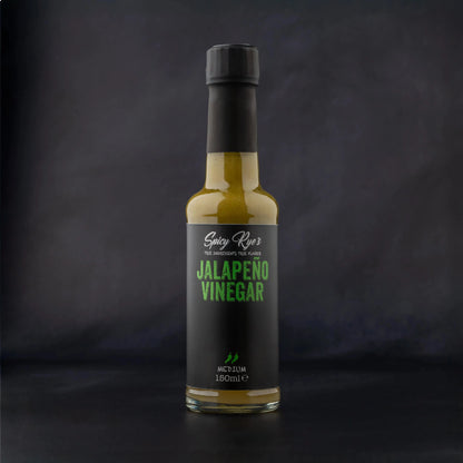 Spicy Ryes Jalapeño Vinegar bottle with vibrant green jalapeño peppers and clear liquid, on a rustic wooden surface.