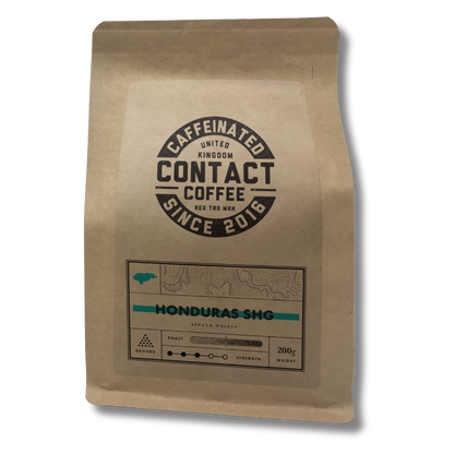Ground Single Origin Honduras SHG coffee from Contact Coffee Company Ltd., showcasing rich, aromatic coffee grounds in a bag.