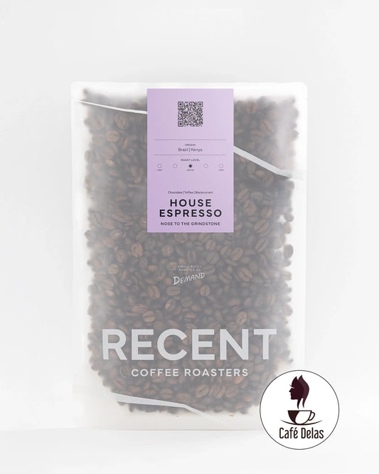 Recent Beans Nose To The Grindstone Medium Roast Coffee in a house espresso cup, showcasing rich coffee grounds and brewed espresso.