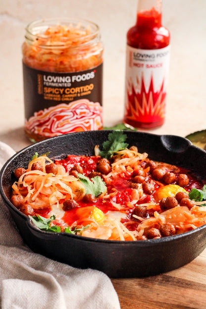 Bottle of Loving Foods organic hot sauce with vibrant red chili peppers and fresh herbs on the label.