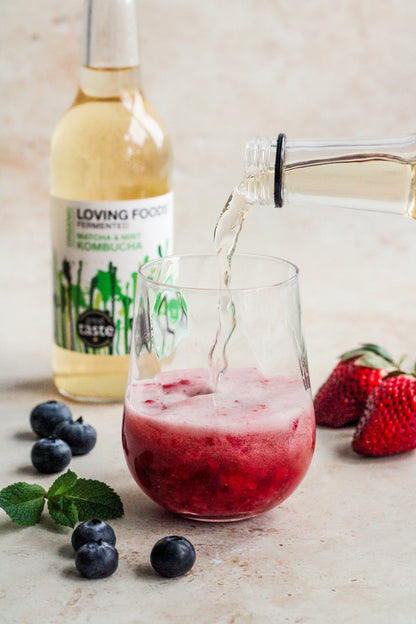 Organic Kombucha by Loving Foods with matcha and mint flavor, showing a glass bottle with vibrant green liquid and fresh mint leaves.