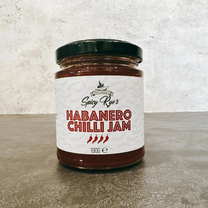 Spicy Ryes Chilli Jam Medley Gift Set featuring assorted jars of spicy chili jams on a wooden surface.