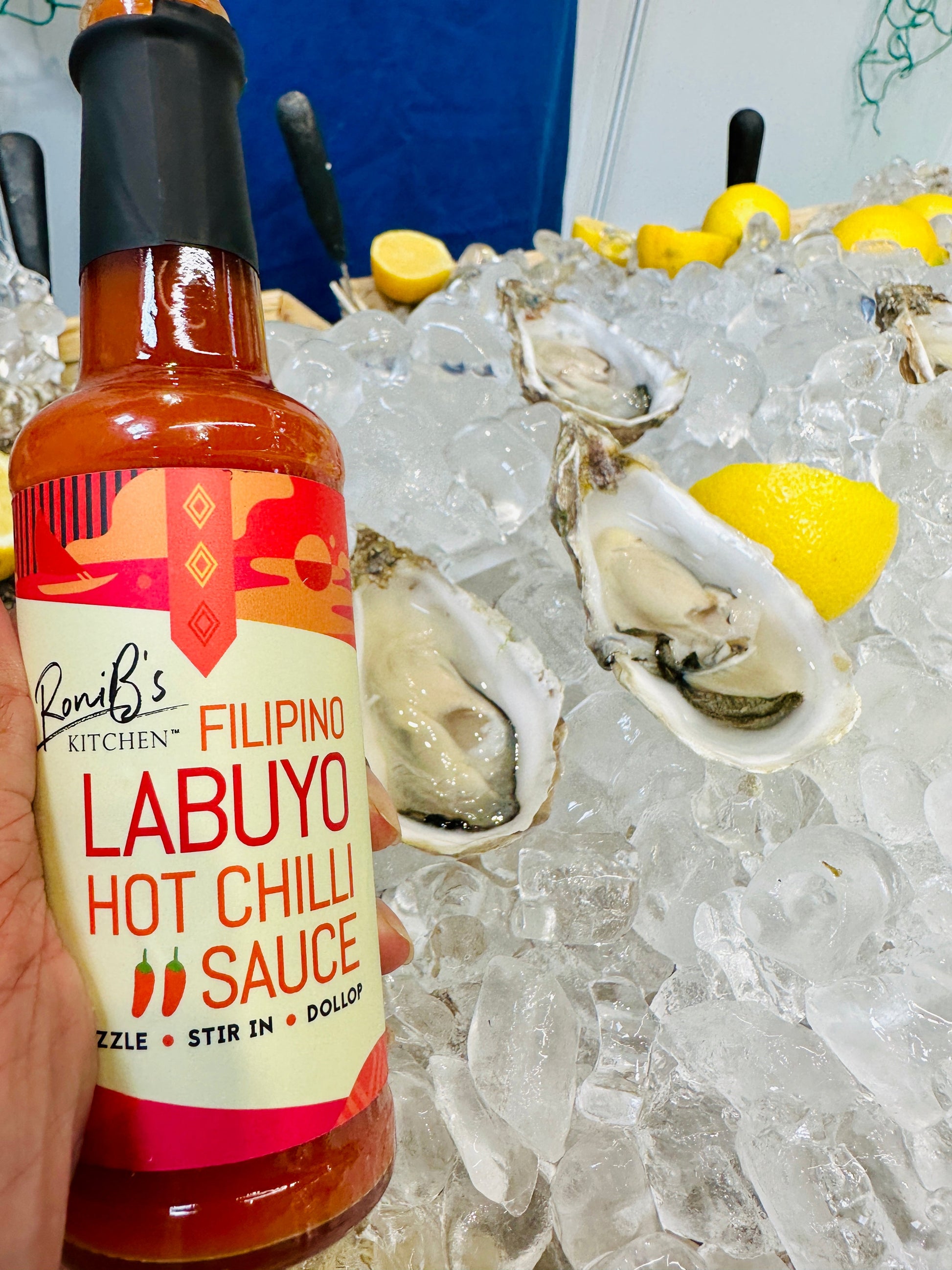 Filipino Style Labuyo Hot Chilli Sauce by RoniBs Kitchen, vibrant red hot sauce in a glass bottle with chili peppers and tropical branding.