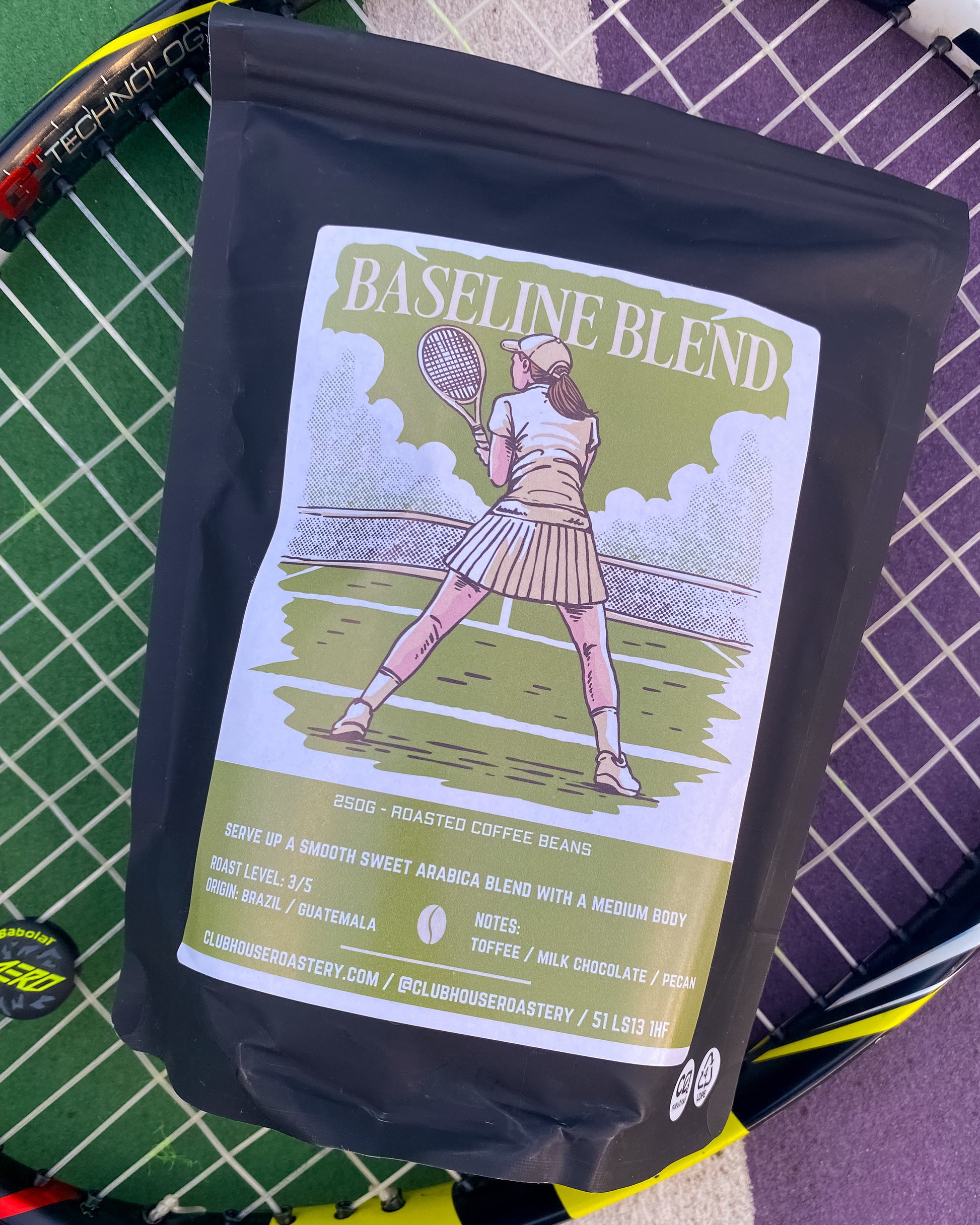 Bag of Clubhouse Roastery Baseline Blend coffee beans, showcasing the roasted coffee blend in a natural setting.