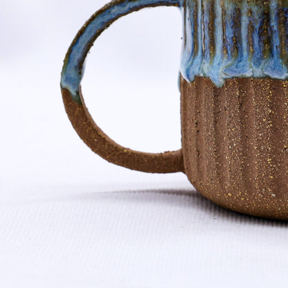 Handmade Terra Stoneware Mug by Ribera Handmade Ceramics with a textured ceramic finish, showcased on a neutral background.