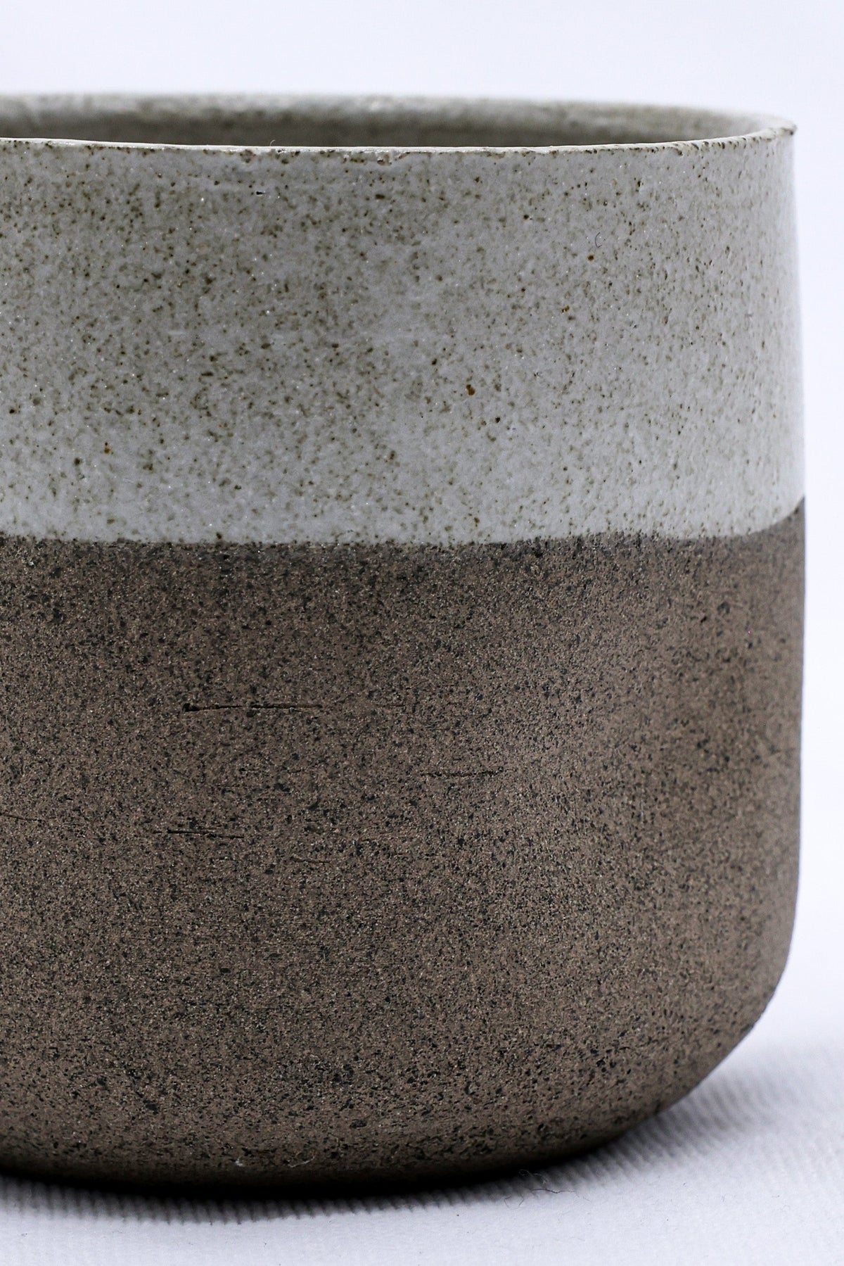 Handmade Bianca Goccio ceramic short cup in smoked grey stoneware by Ribera Handmade Ceramics, showcasing its textured surface and shape.