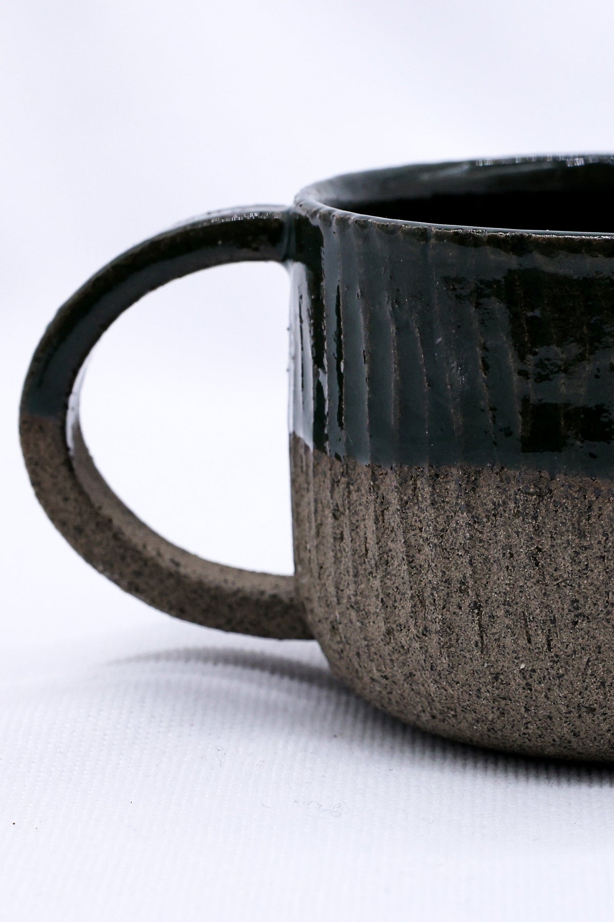 Handmade Bluverde Arte ceramic smoked grey stoneware mug by Ribera Handmade Ceramics, showcasing its textured surface and artisanal design.