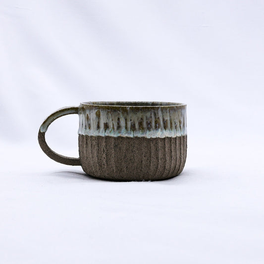 Beige Arte handmade ceramic mug with smoked grey stoneware finish by Ribera Handmade Ceramics, showing smooth, rounded shape and textured surface.