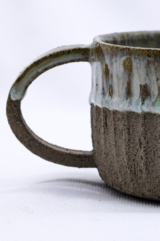 Beige Arte handmade ceramic mug with smoked grey stoneware finish, featuring a rustic, textured surface and ergonomic handle.