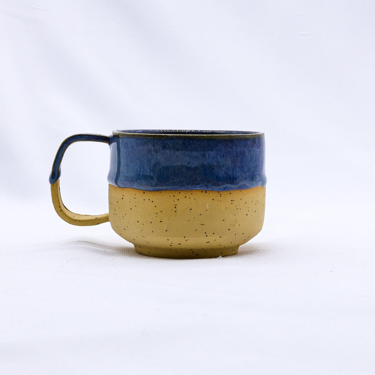 Ribera Handmade Ceramics Bluvio Sienna ceramic mug with a textured stoneware surface and a rounded handle on a plain background.