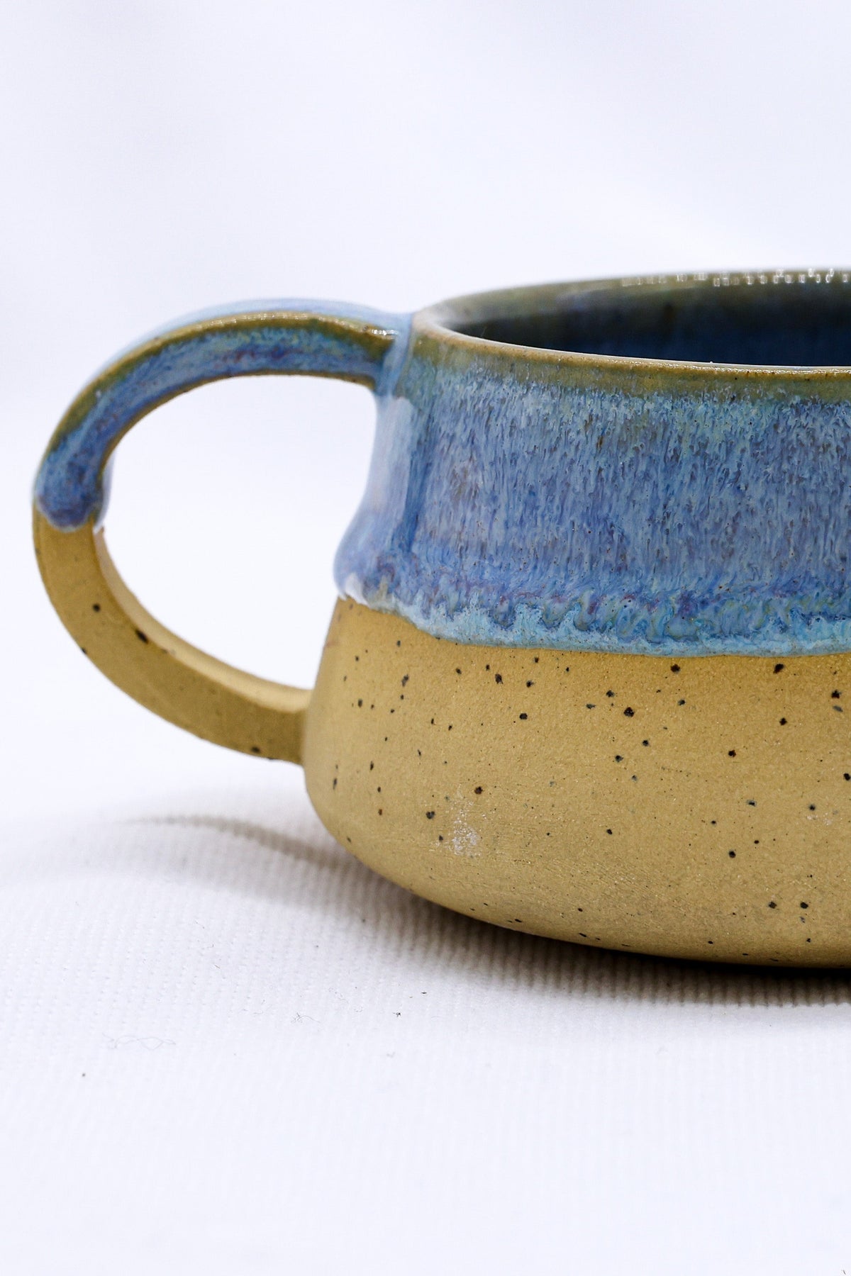 Handmade stoneware ceramic mug by Ribera Handmade Ceramics with a rustic finish and unique design, suitable for coffee or tea.