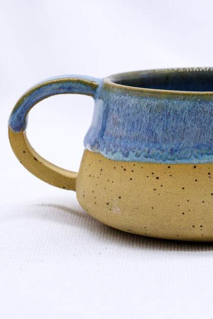 Handmade stoneware ceramic mug by Ribera Handmade Ceramics with a rustic finish and unique design, suitable for coffee or tea.