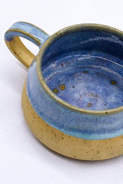 Handmade stoneware ceramic mug by Ribera Handmade Ceramics with a rustic, textured finish and a curved handle.