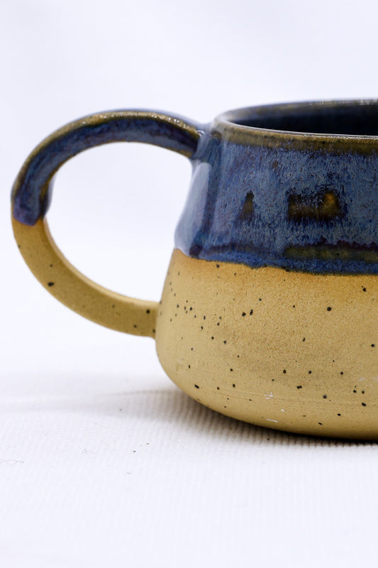 Handmade Bluverde Belluma ceramic mug by Ribera Handmade Ceramics, showing a blue and beige stoneware mug on a neutral background.