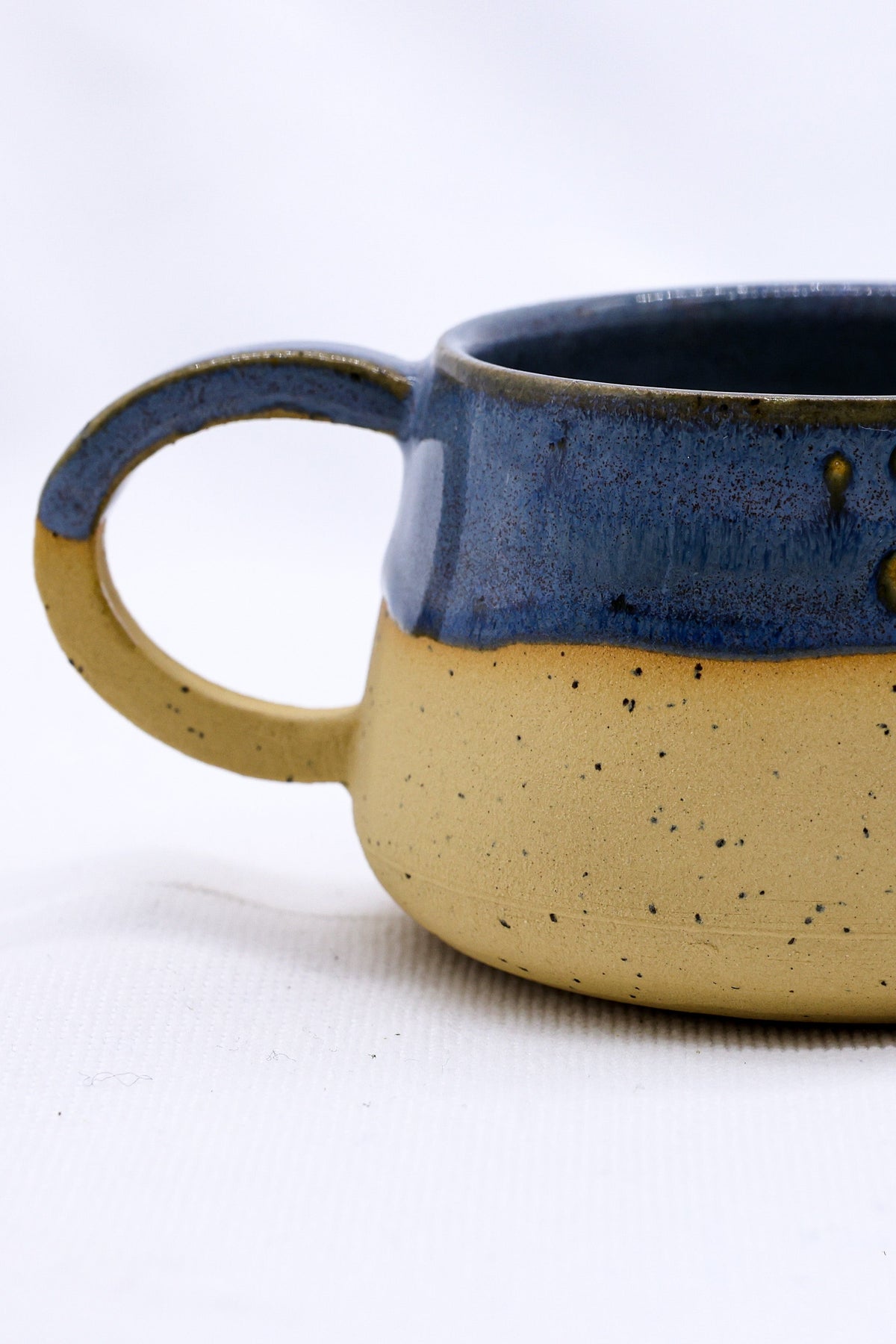 Ribera Handmade Ceramics Bluvio Belluma stoneware ceramic mug with a rustic, textured finish, featuring a sturdy handle and handcrafted details.