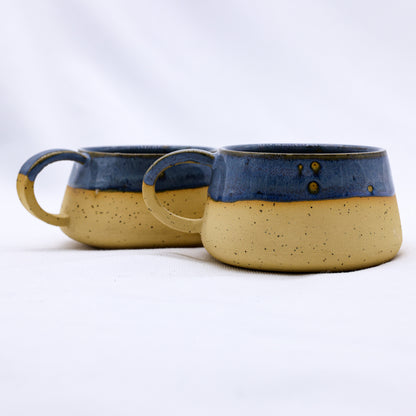 Blue and earthy-toned Bluvio Belluma handmade stoneware ceramic mug by Ribera Handmade Ceramics, showcasing its textured surface and unique shape.