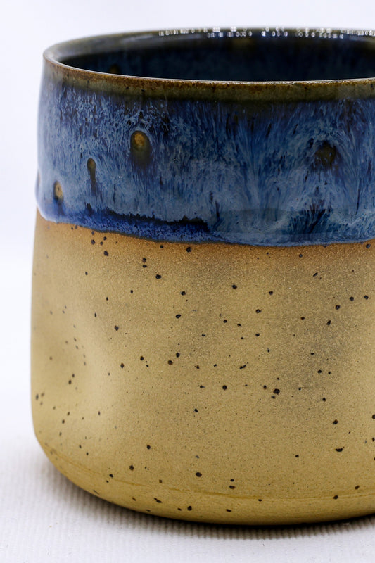 Handmade ceramic stoneware cup from Ribera Handmade Ceramics, featuring a textured blue Goccia design on a rustic surface.