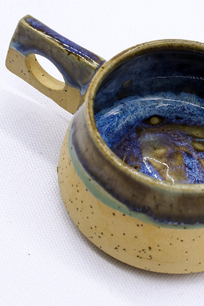 Blue and beige handmade ceramic coffee mug by Ribera Handmade Ceramics, with a rustic stoneware finish and unique shape.