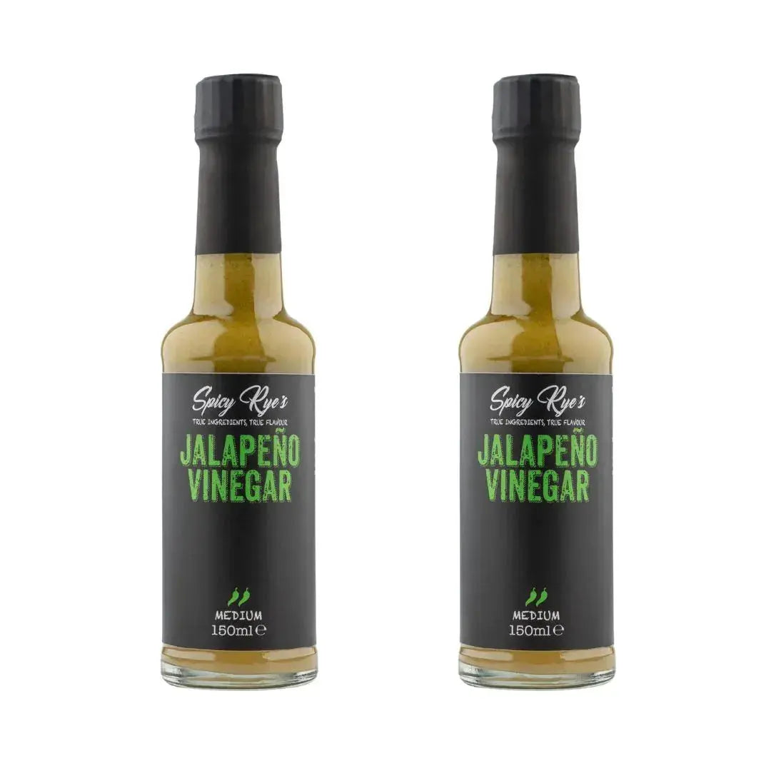Two bottles of Spicy Ryes Jalapeño Vinegar with green jalapeño peppers in clear glass bottles on a white background.