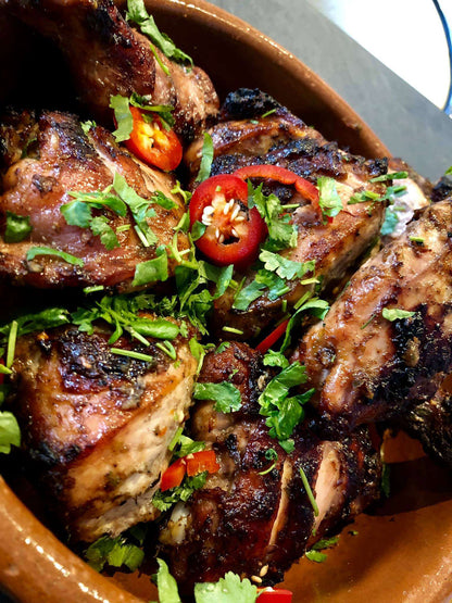 FireFly Barbecue Boston Beach Jerk Rub on seasoned jerk chicken, showcasing vibrant spices and grilling details.
