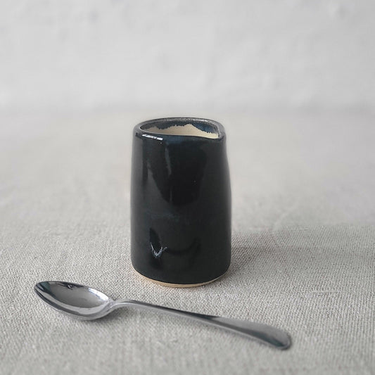 Jet black mini jug with a small spoon by Katie L Thompson Designs, perfect for serving sauces or condiments.