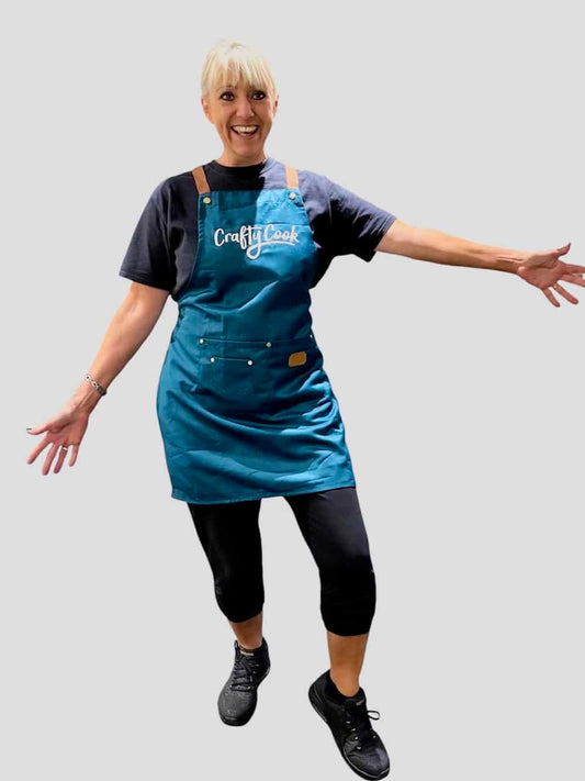 Teal Crafty Cook apron with multiple pockets, made of durable fabric, designed for cooking and baking.