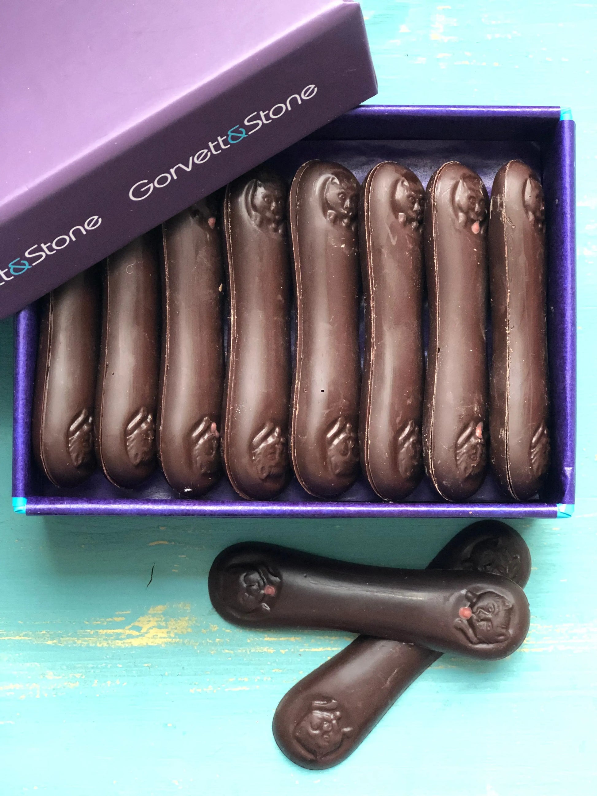 Dark Langues de Chats cookies from Gorvett & Stone, crispy French biscuit cookies on a white plate.