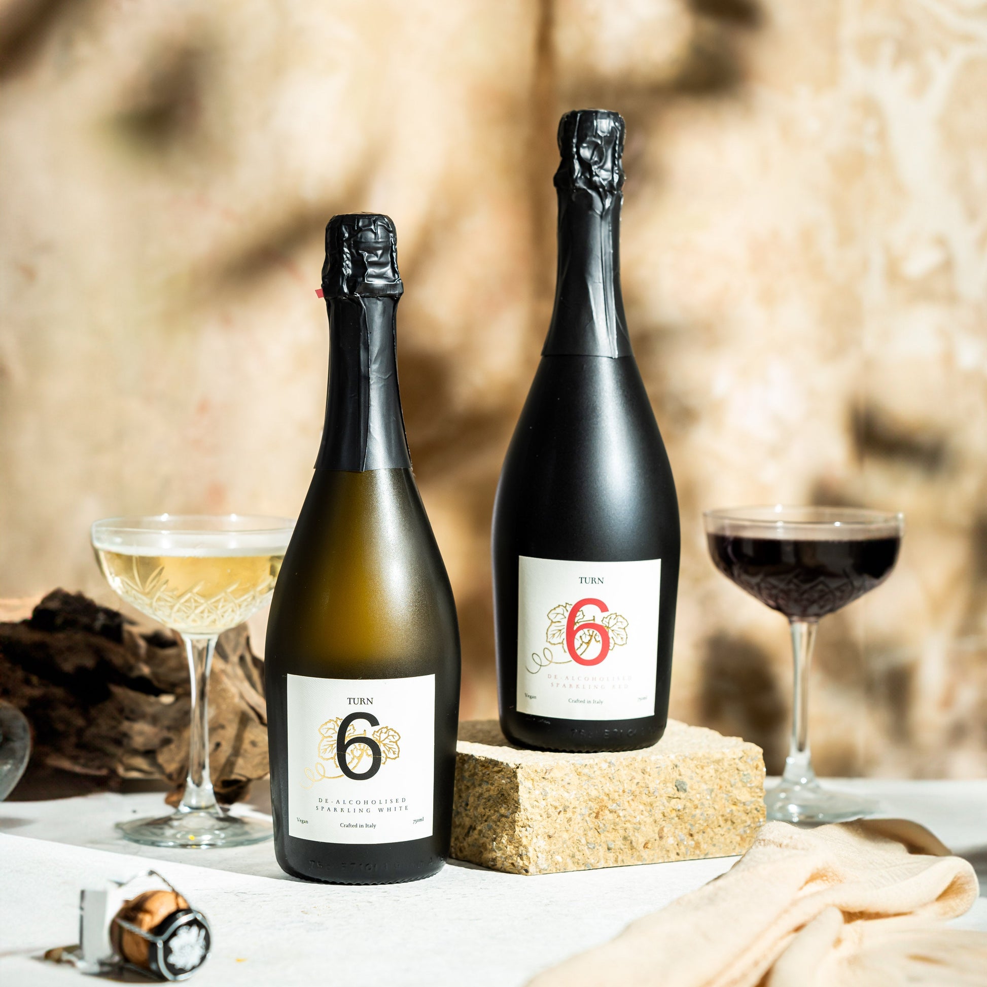 Six-pack of Turn 6 alcohol-free sparkling white and red wine bottles with vibrant labels and elegant packaging.