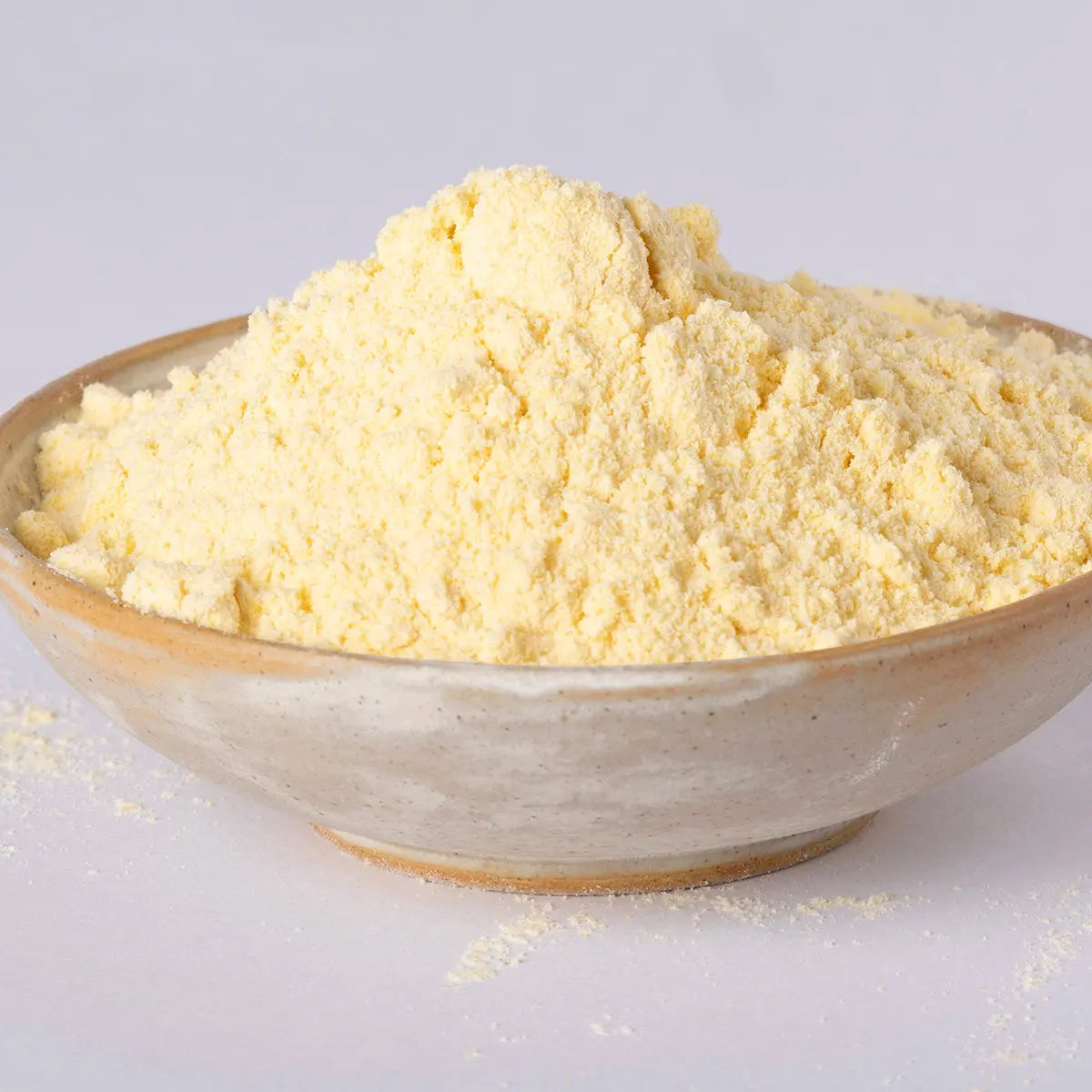 Whole Food Earth maize flour in a bowl, showing golden yellow cornmeal, suitable for baking and cooking with natural maize grains.