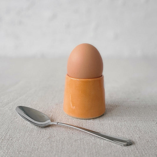 Mandarin orange ceramic egg cup by Katie L Thompson Designs, featuring a vibrant orange fruit design for breakfast serving.