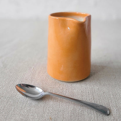 Small ceramic mandarin orange jug by Katie L Thompson Designs with a classic shape and vibrant orange color.