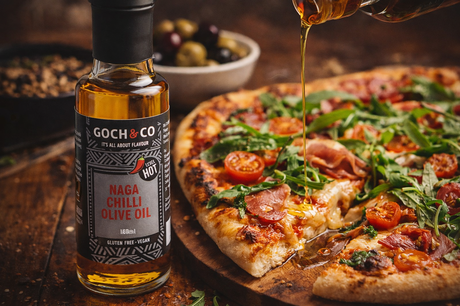 Chilli Olive Oil drizzling over a freshly baked sliced pizza on a wooden board