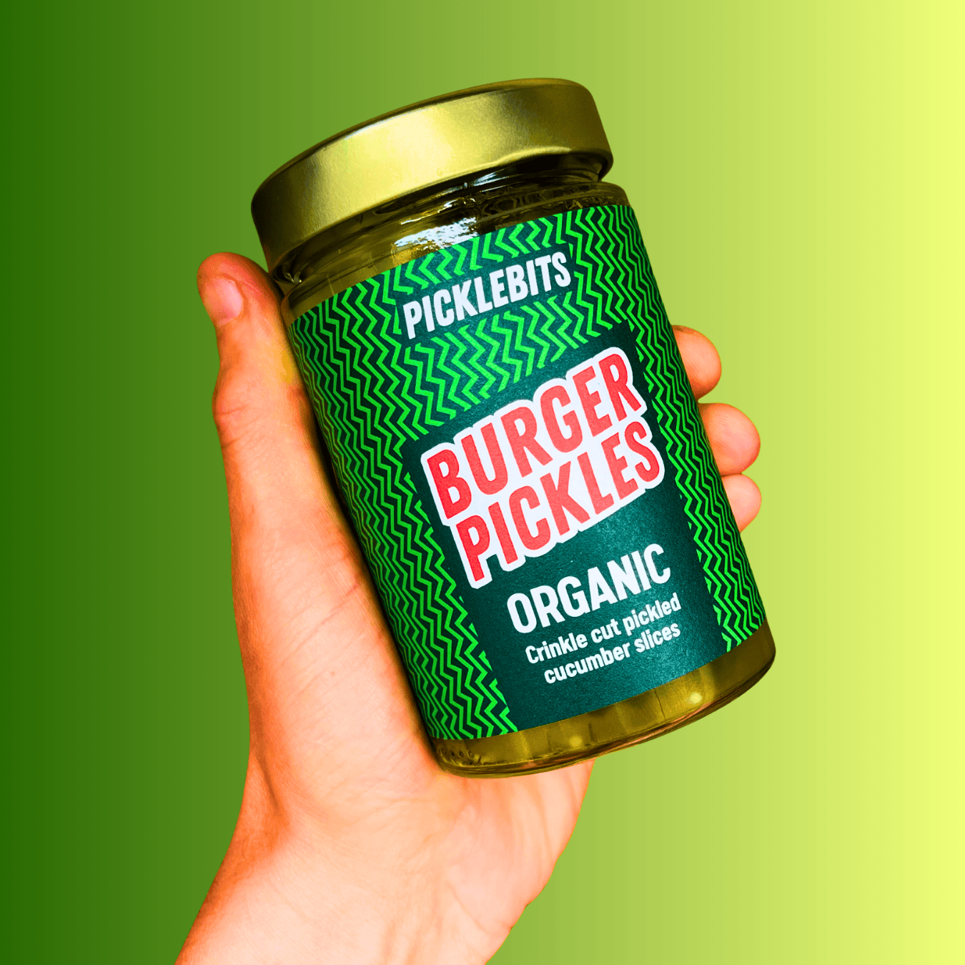 Organic Dill and Garlic Burger Pickles by PICKLEBITS, crinkle-cut pickled cucumber slices in a glass jar.