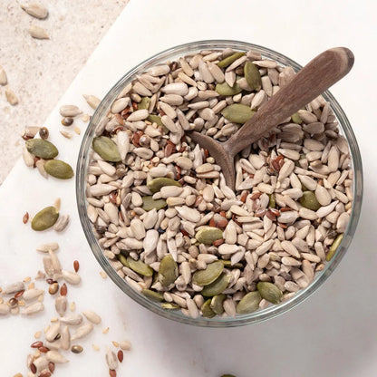 Omega Seed Mix by Whole Food Earth featuring a colorful blend of five nutritious seeds in a clear container.
