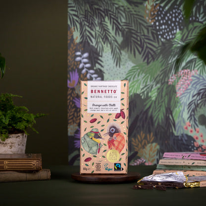 Bennetto Natural Foods UK chocolate bar featuring orange and chili flavors, with vibrant orange and red chili pieces visible.