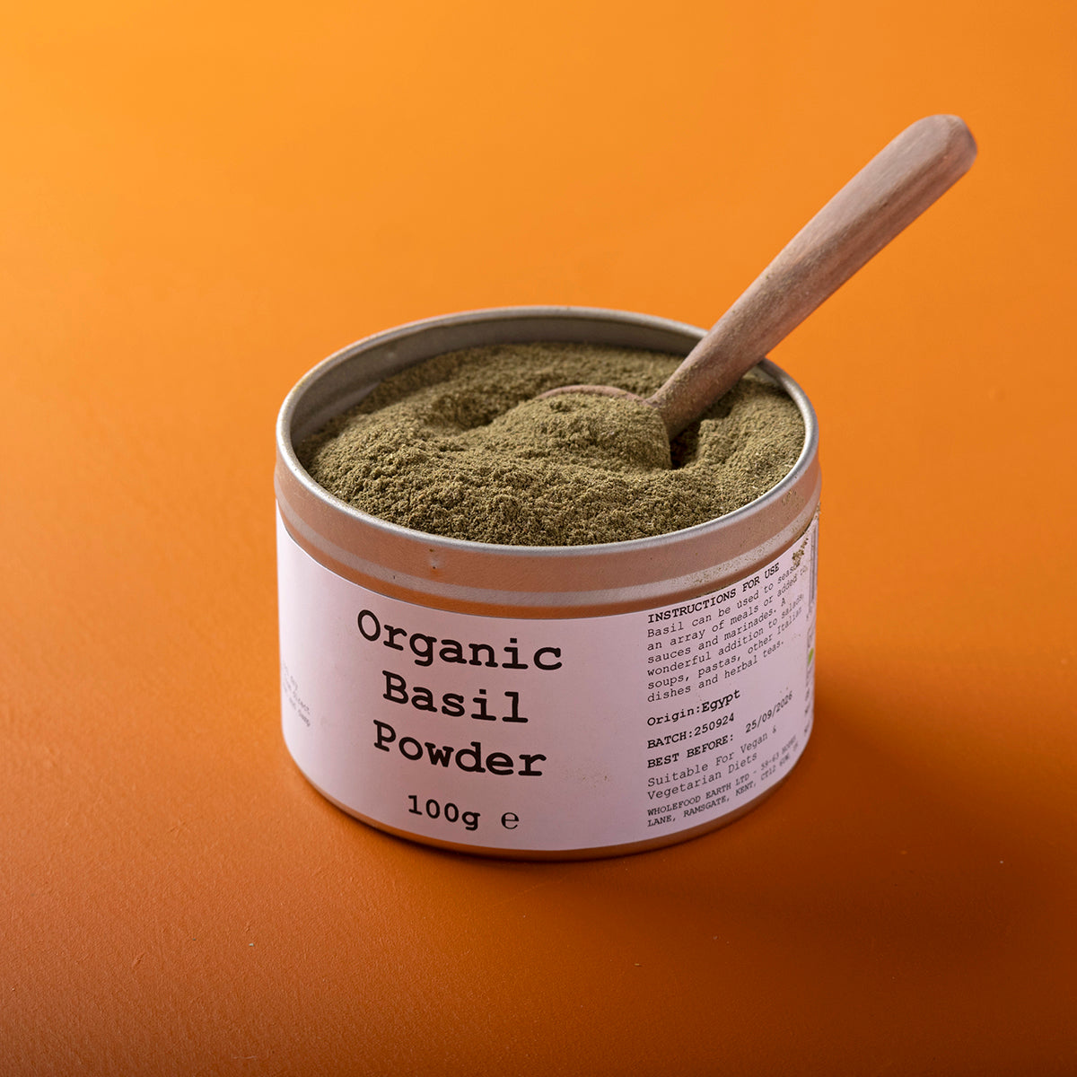 Organic basil powder from Whole Food Earth, wild-crafted herb in a 100g package, showcasing fresh, finely ground basil leaves.