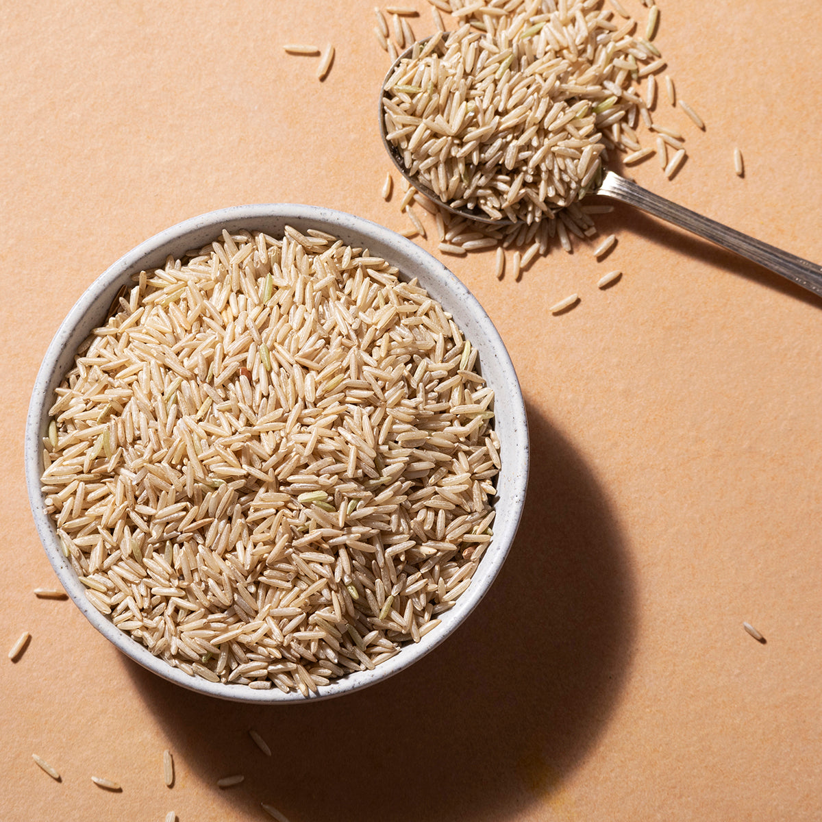 Organic brown basmati rice grains in a clear bowl, showcasing the Whole Food Earth rice and couscous product.
