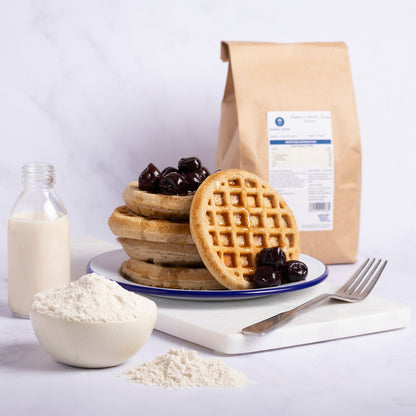 Organic brown rice flour from Whole Food Earth in a kitchen setting, showing a bowl of flour and a measuring cup on a wooden surface.