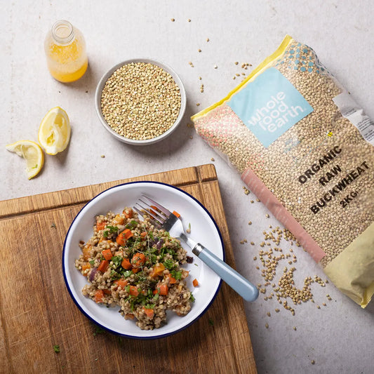 Organic Buckwheat grains from Whole Food Earth, displayed in a natural kitchen setting with a bowl and spoon.