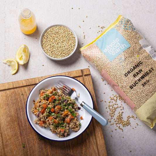 Organic Buckwheat grains in a rustic bowl with a wooden spoon, showcasing the natural, wholesome appearance of ArtisanBox organic buckwheat.