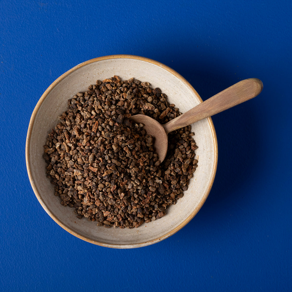 Organic wild elephant cardamom seeds in a clear jar, showcasing green, aromatic spice used in herbs and spices.